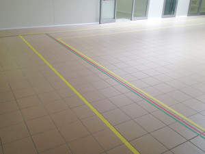 Decorazione pavimenti con nastri segnaletici removibili e vetrate ingresso con pellicola a controllo solare specchiato.