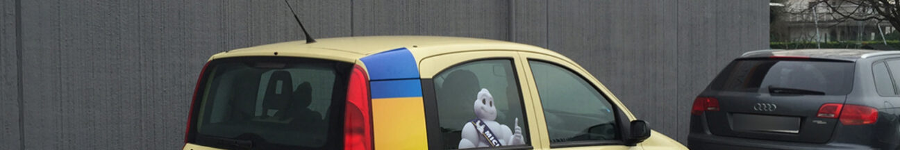 Decorazione auto sostitutiva pubblicitaria con adesivi stampati ed intagliati e adesivi prespaziati